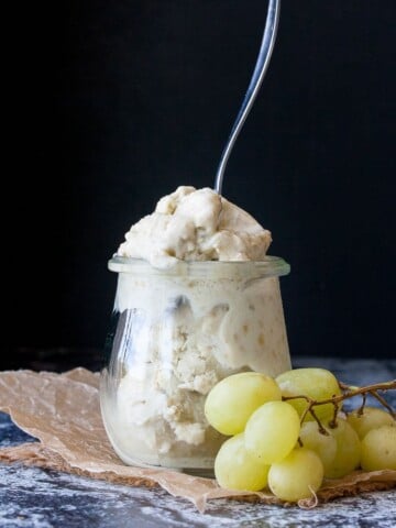 Instant frozen yogurt in a glass jar with a spoon sticking it it