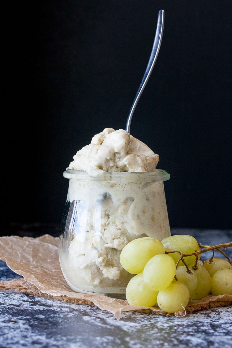 Instant frozen yogurt in a glass jar with a spoon sticking it it