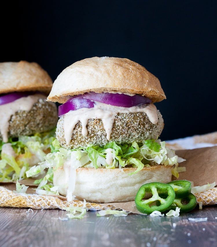 Vegan maple mustard falafel sliders on a wooden surface and black background