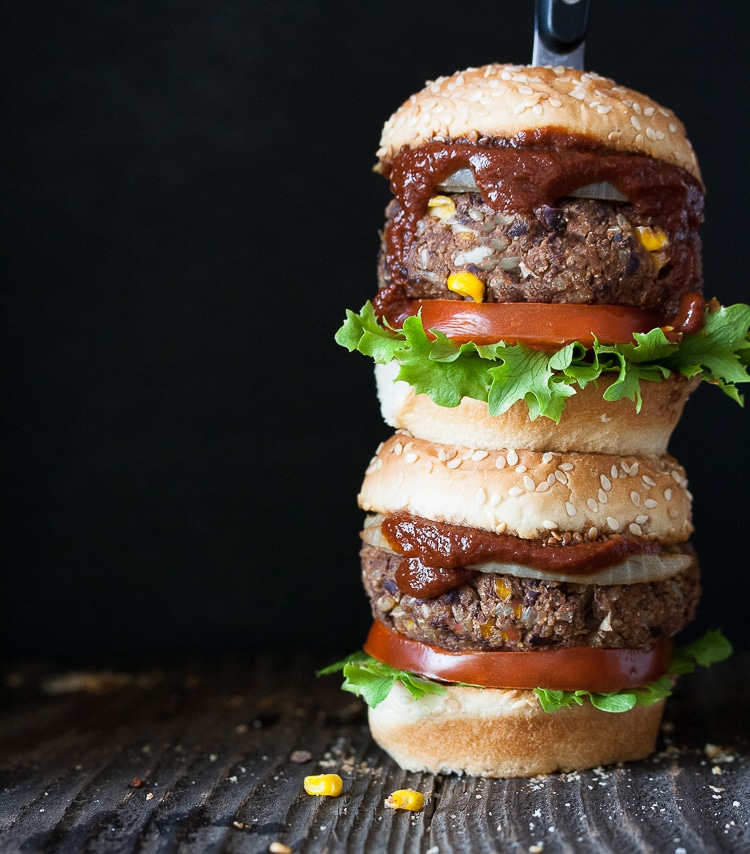 Vegan down home bbq burgers stacked on top of each other with black background