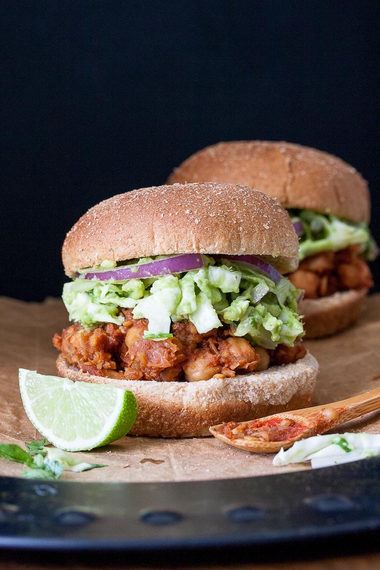 A photo of vegan bbq sliders sitting on brown paper with lime wedges