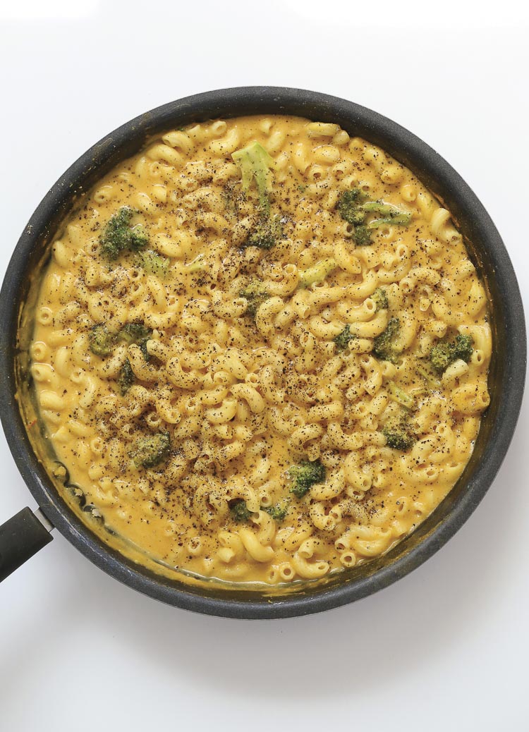 Top view of black pepper mac and cheese with broccoli in a skillet