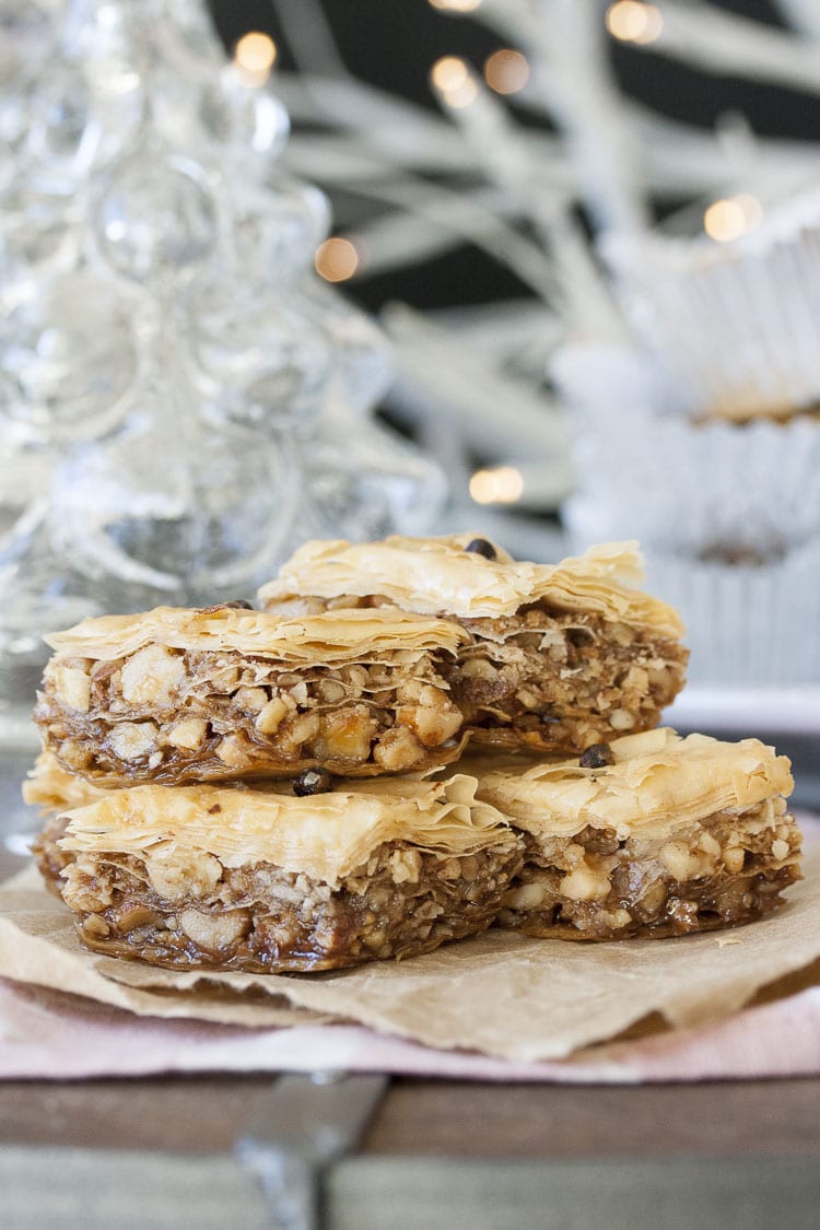 Four pieces of Greek vegan baklava stacked on a piece of parchment paper