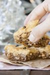 Hand grabbing a piece of Greek vegan baklava off of a stack of baklava