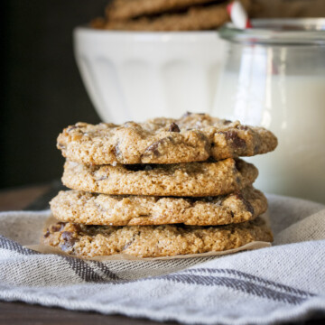 Pile of four sea salt chocolate chip cookies on a grey towel