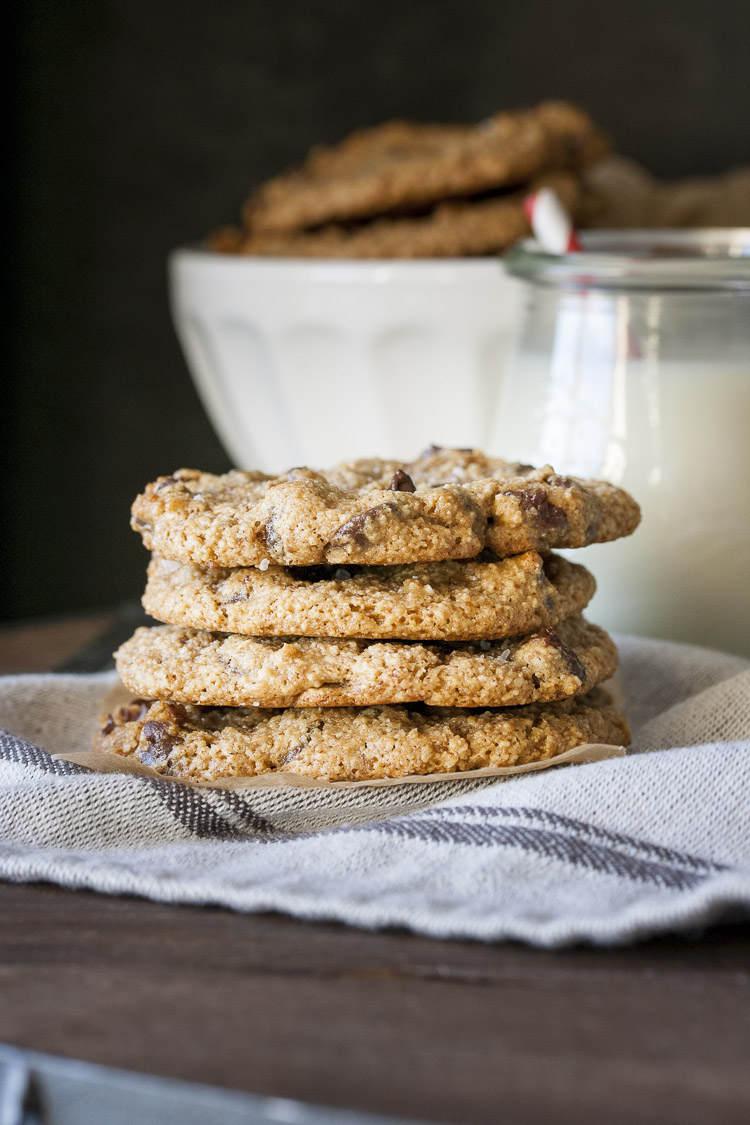 Pile of four sea salt chocolate chip cookies on a grey towel