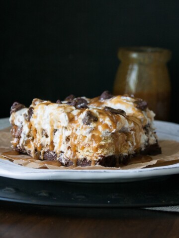 A slice of vegan dessert lasagna on a white plate drizzled with caramel sauce