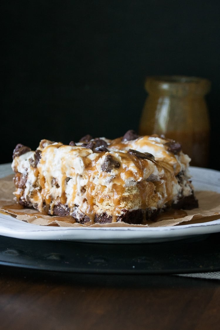 A slice of vegan dessert lasagna on a white plate with a dark background