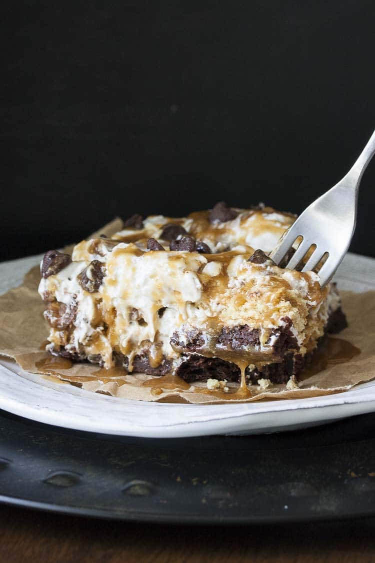 vegan dessert lasagna with 7 layers on a plate and a fork picking up a bite