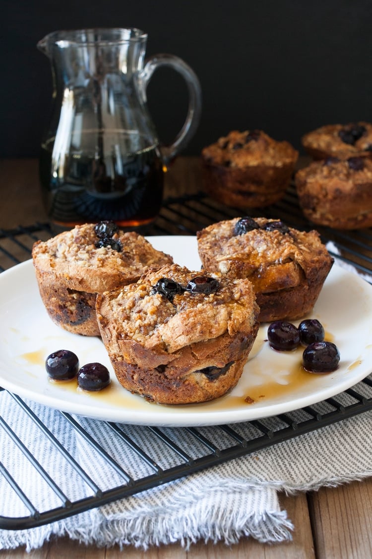 White plate with three blueberry french toast muffins on it.