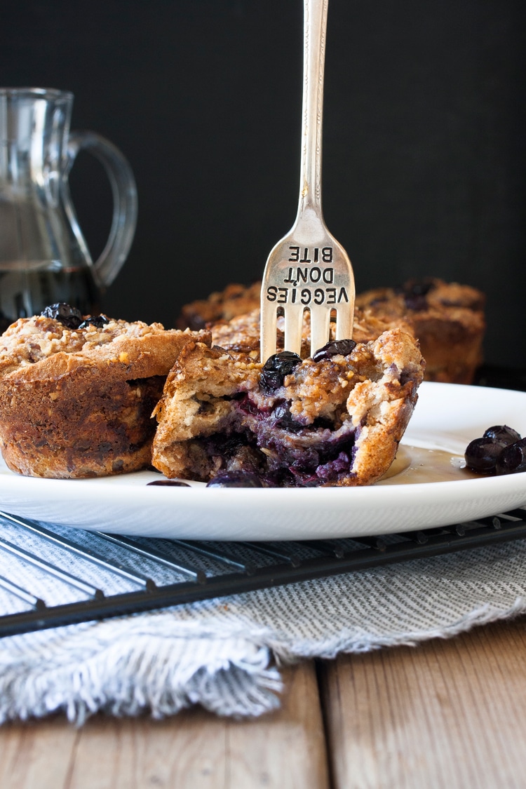 Fork stabbed in the top of a half eaten blueberry french toast muffin
