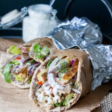 Two tempeh vegan greek gyros rolled up in pita bread and foil