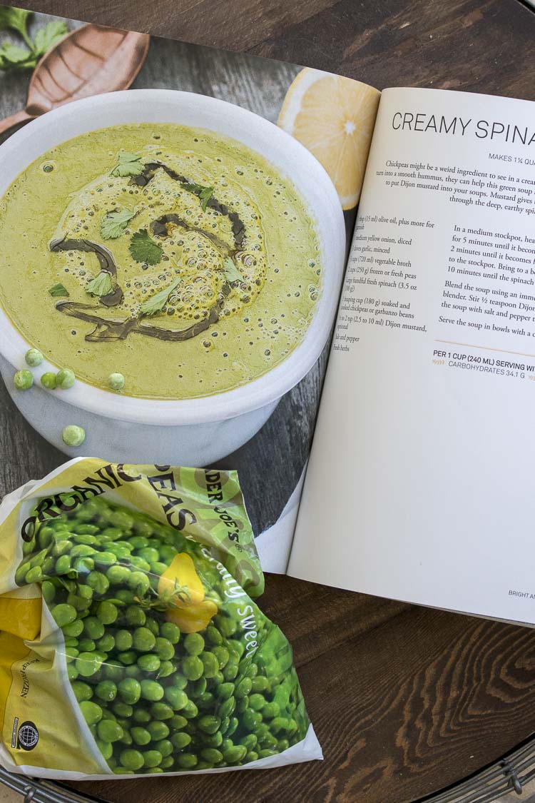 Cookbook recipe for creamy spinach pea soup next to bag of peas