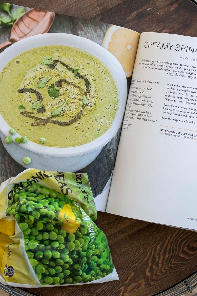 Cookbook recipe for creamy spinach pea soup next to bag of peas