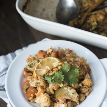 Front view of vegetables and rice with harissa flavors in a white plate