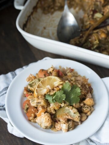 Front view of vegetables and rice with harissa flavors in a white plate