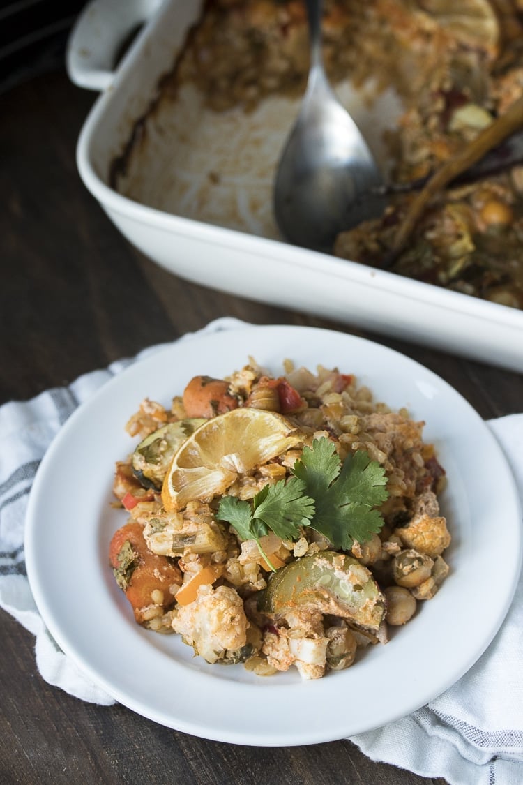 Front view of vegetables and rice with harissa flavors in a white plate