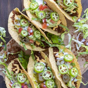Top view of fully loaded crispy vegan tacos on a wooden table