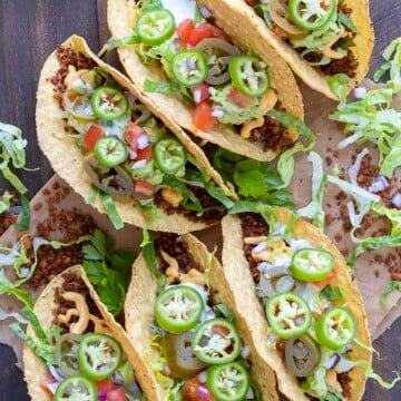 Top view of fully loaded crispy vegan tacos on a wooden table