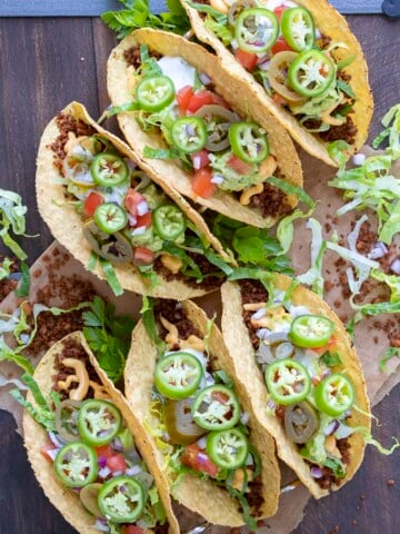 Top view of fully loaded crispy vegan tacos on a wooden table