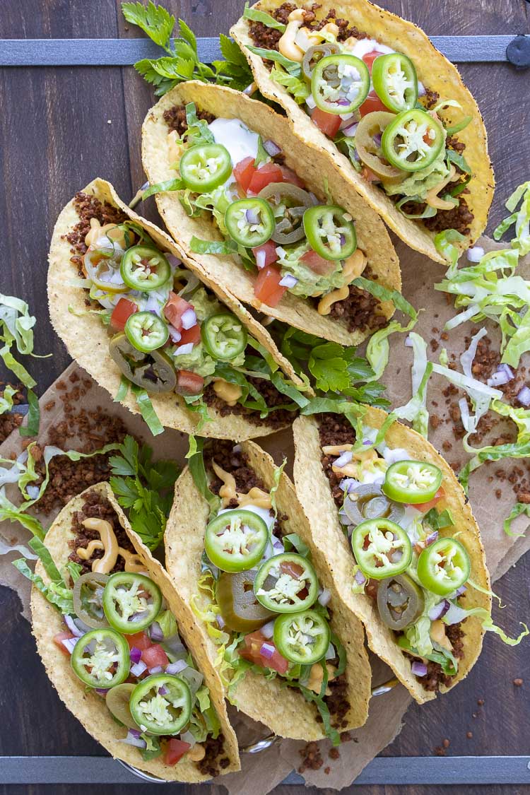 Top view of fully loaded crispy vegan tacos on a wooden table