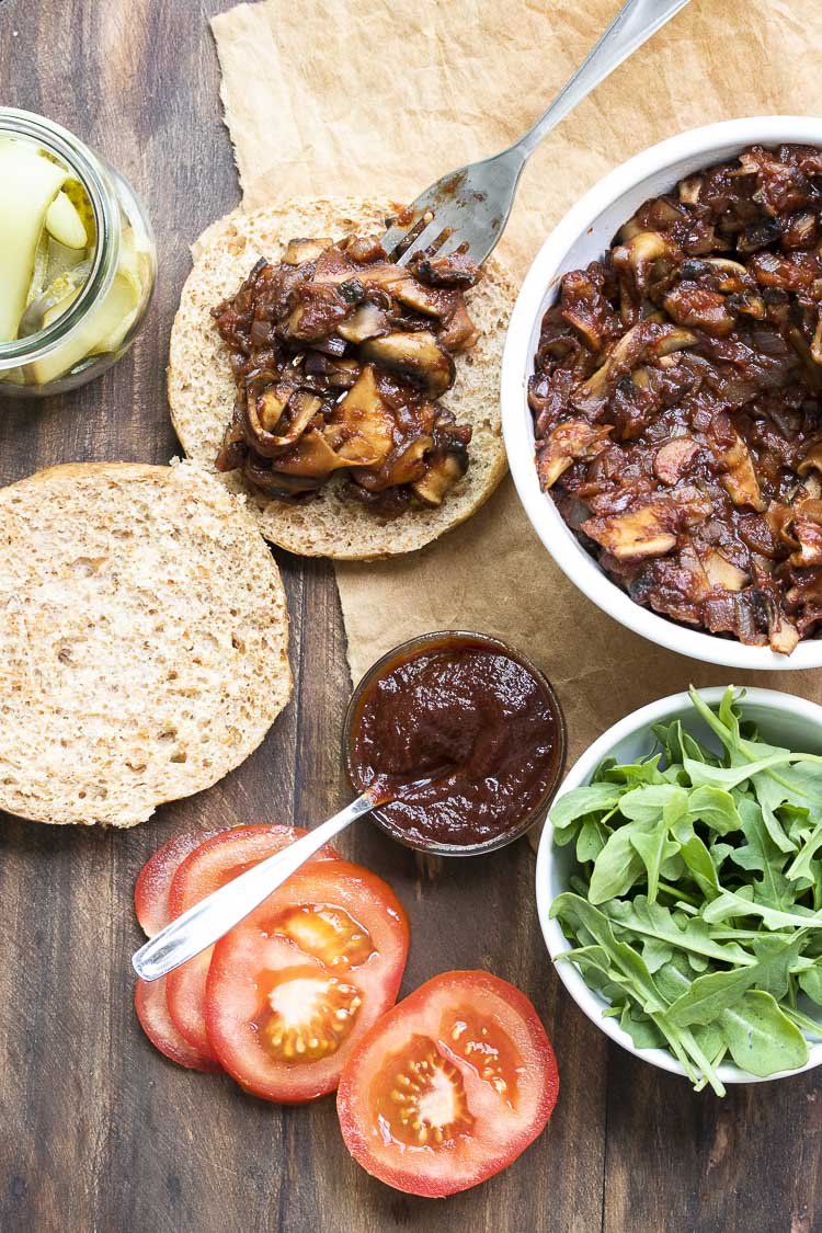 Top view of vegan pulled pork sandwich being constructed on a wooden table