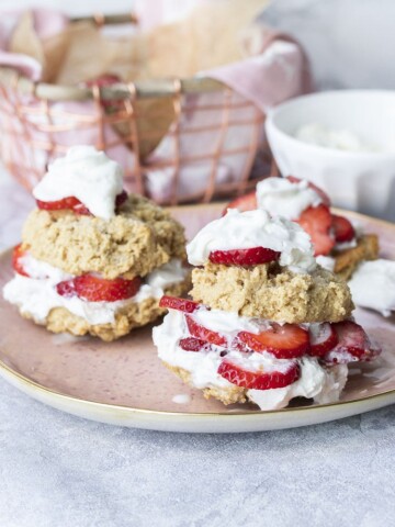 Front view of two strawberry shortcakes on a pink plate