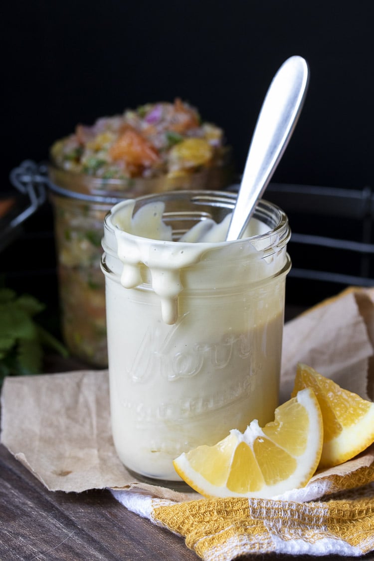Glass jar of light peach creamy sauce with spoon in it