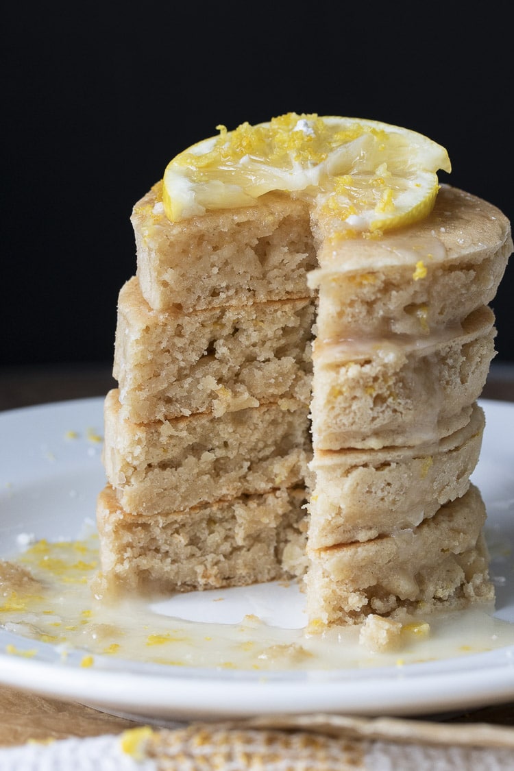 Stack of lemon ricotta pancakes with a slice cut out