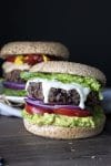 Black bean burger topped with lettuce, ranch dressing, red onions, tomato and avocado