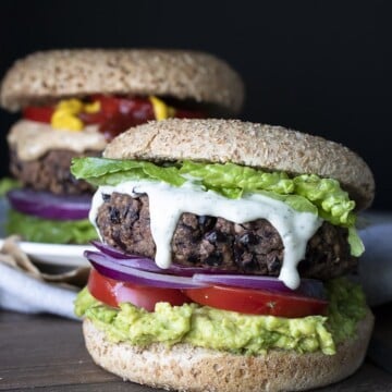 Black bean burger topped with lettuce, ranch dressing, red onions, tomato and avocado