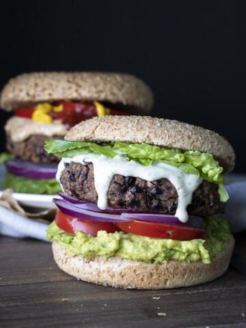 Black bean burger topped with lettuce, ranch dressing, red onions, tomato and avocado