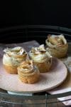 Three apple roses with powdered sugar on a pink plate