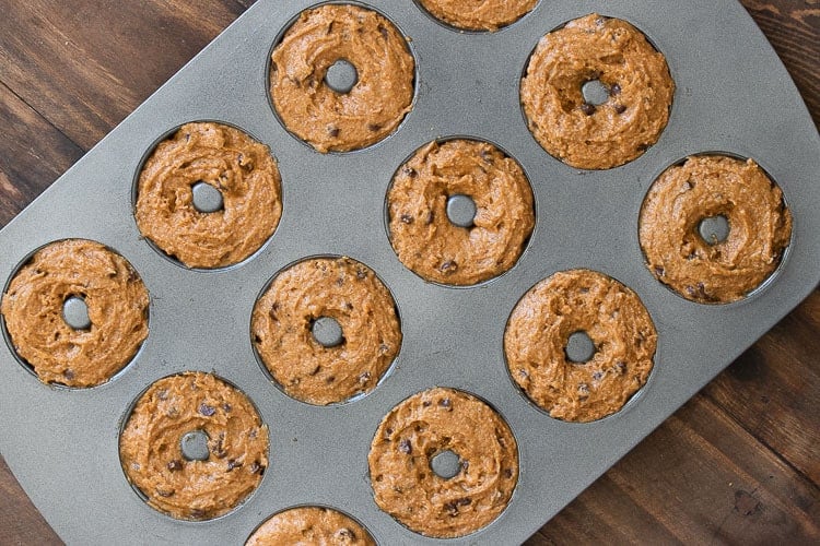 Metal donut pan willed with tan donut batter