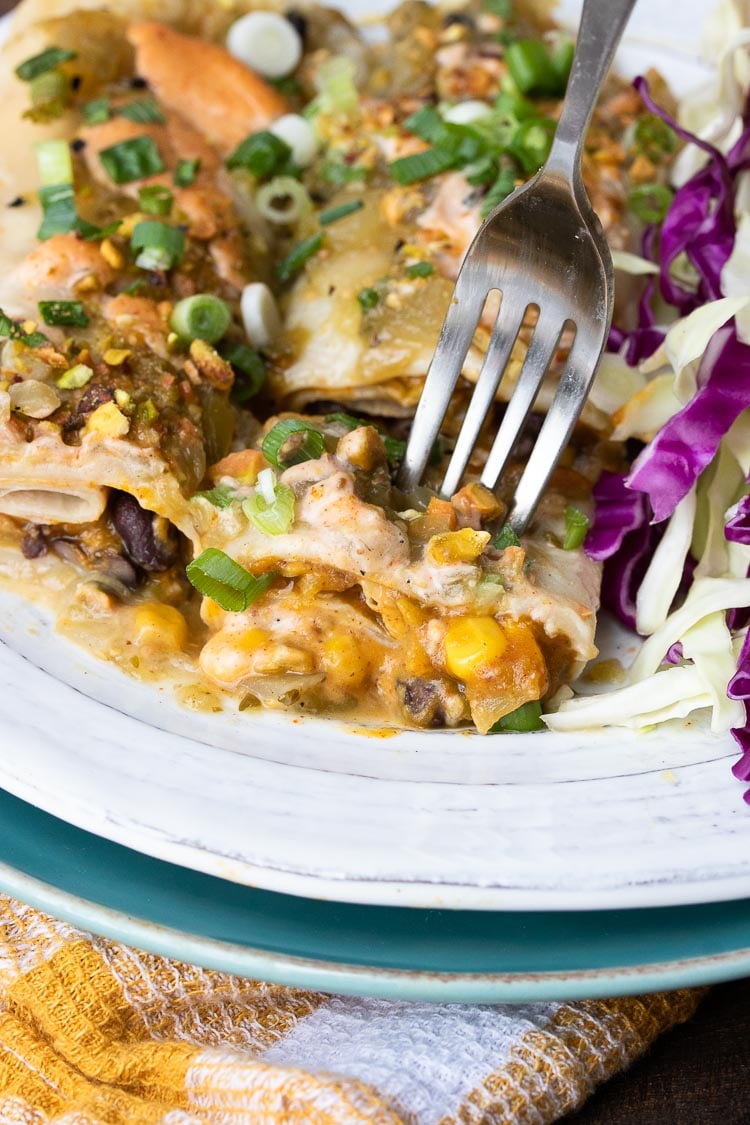 Fork getting a bit of pumpkin enchiladas with black beans