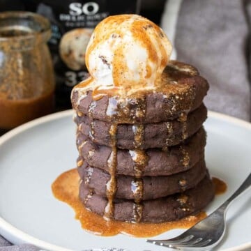 Gray plate with a pile of chocolate pancakes topped with a scoop of ice cream