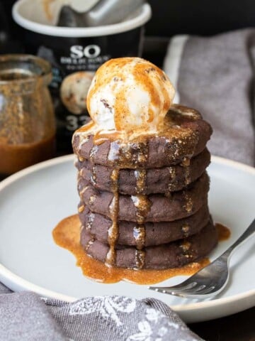 Gray plate with a pile of chocolate pancakes topped with a scoop of ice cream