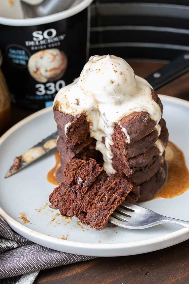 Fork with a pile of chocolate pancake bites laying next to a stack of pancakes