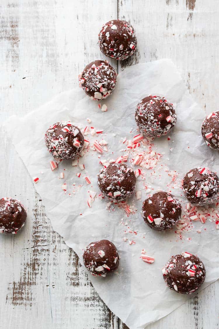 Brownie balls covered in crushed candy cane spread out on a white wooden table