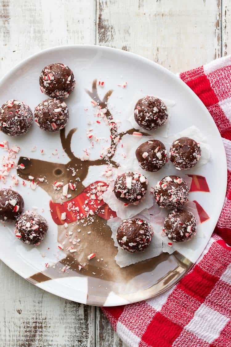 Candy cane covered brownie balls on a white plate with a reindeer on it