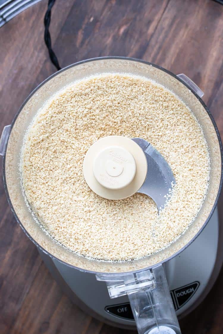 Food processor filled with finely ground cashews