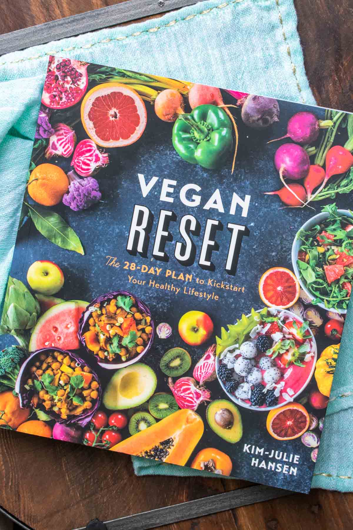 Cover of a vegan cookbook with veggies and fruits on the front