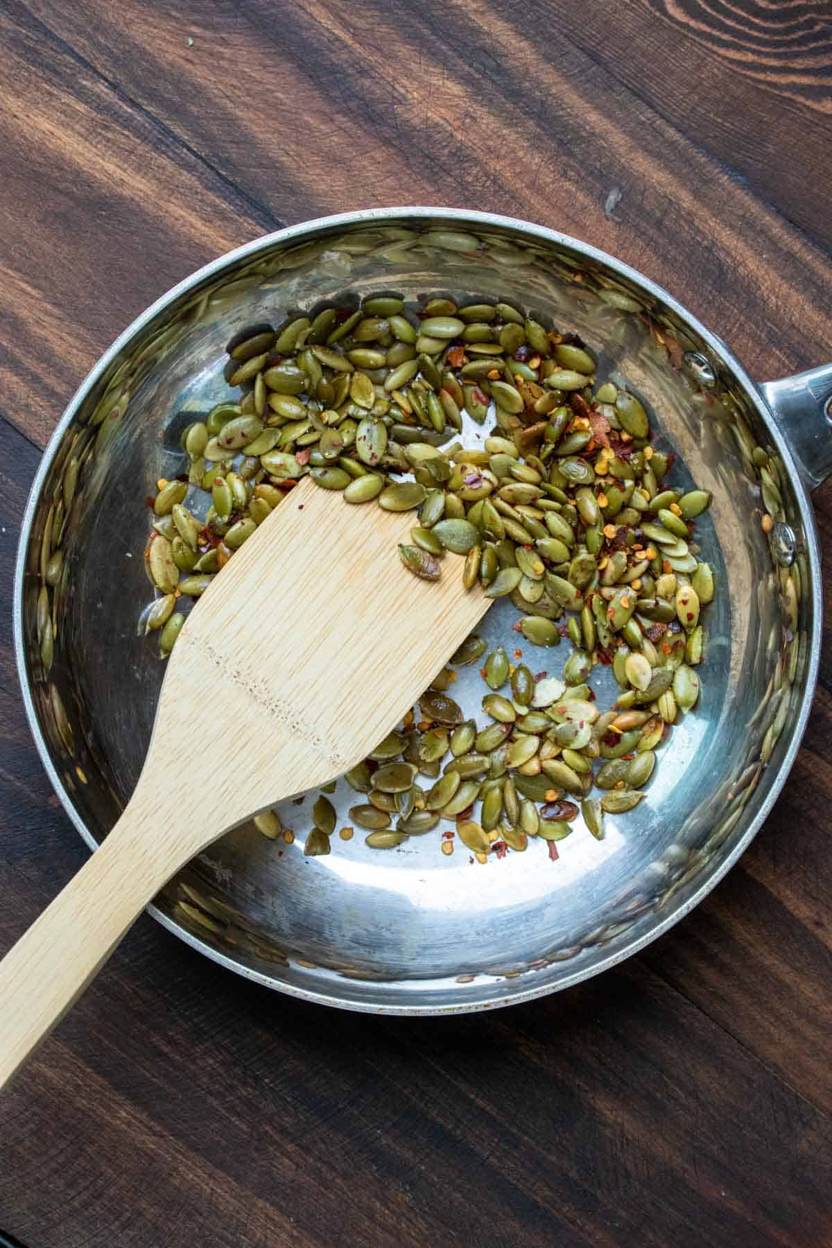 Pumpkin seeds and spices cooking in a pan