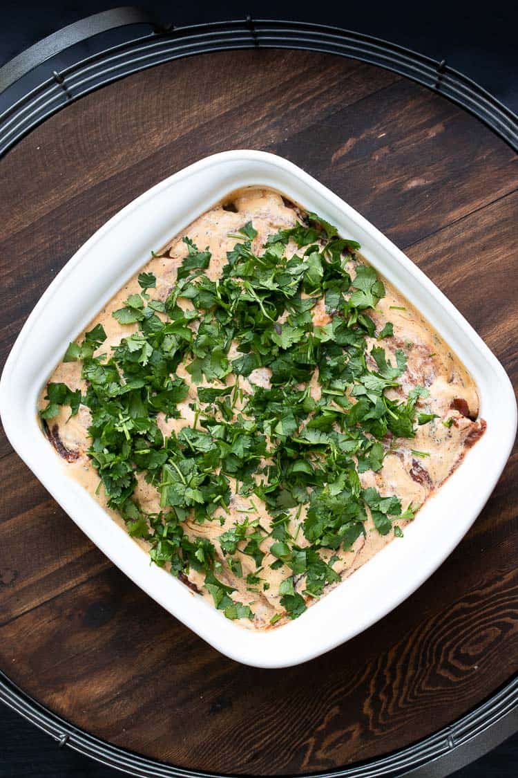 Top view of chickpea and spinach enchiladas with creamy pink sauce on top