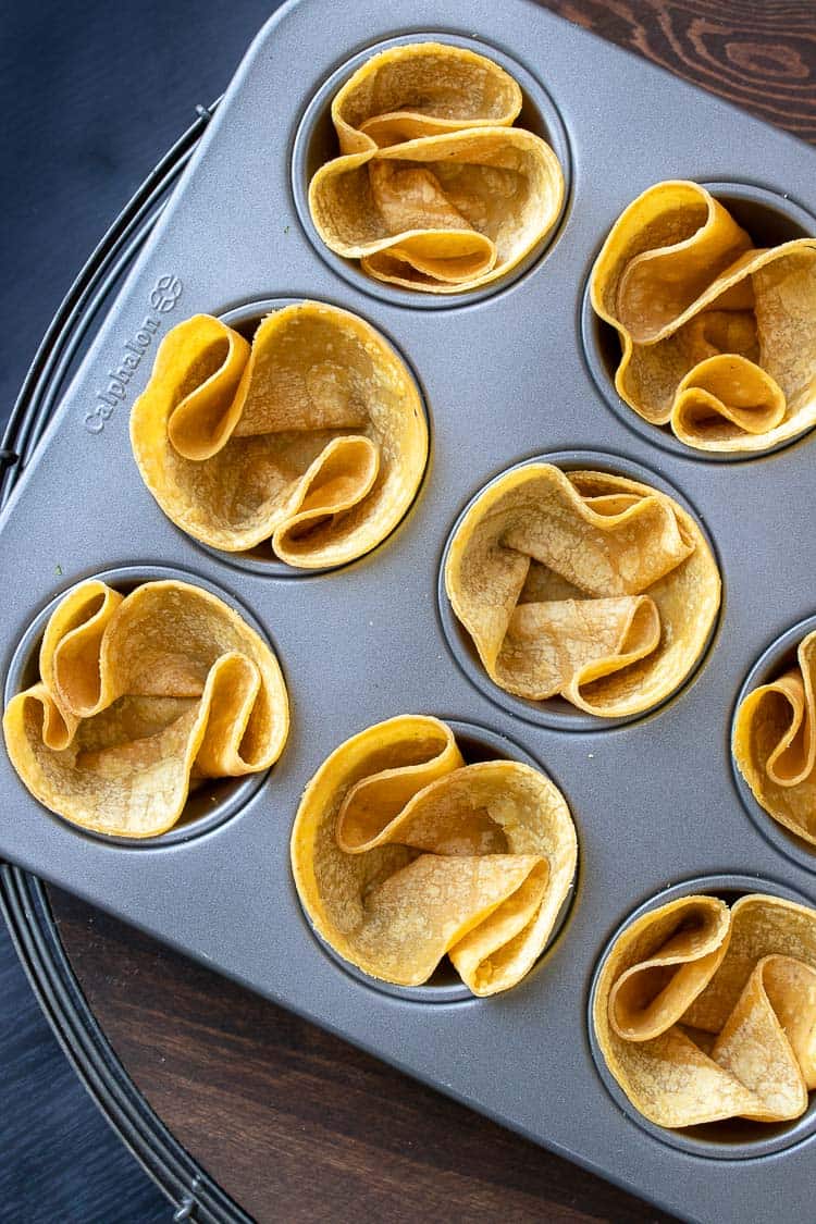 Muffin tin with corn tortillas folded inside