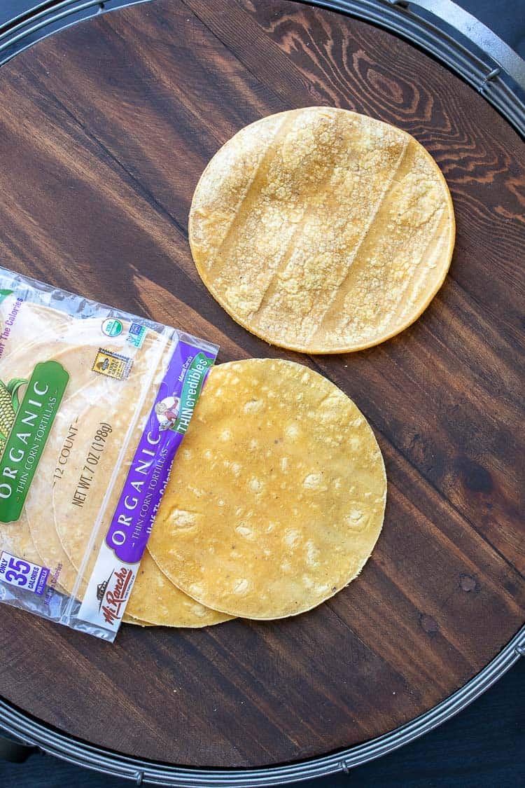 Tortillas coming out of a package laying on a wood tray