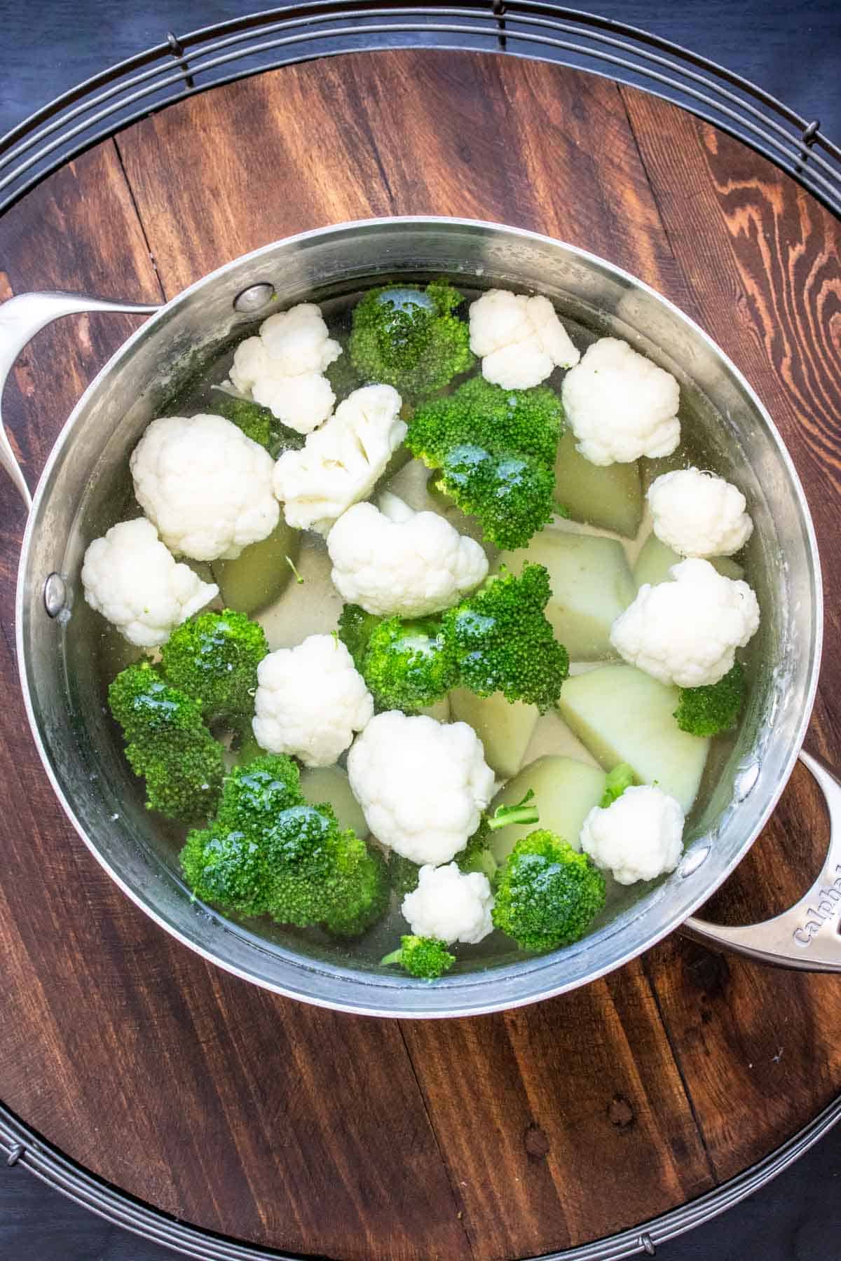Cauliflower, broccoli and potato cooking in a pot