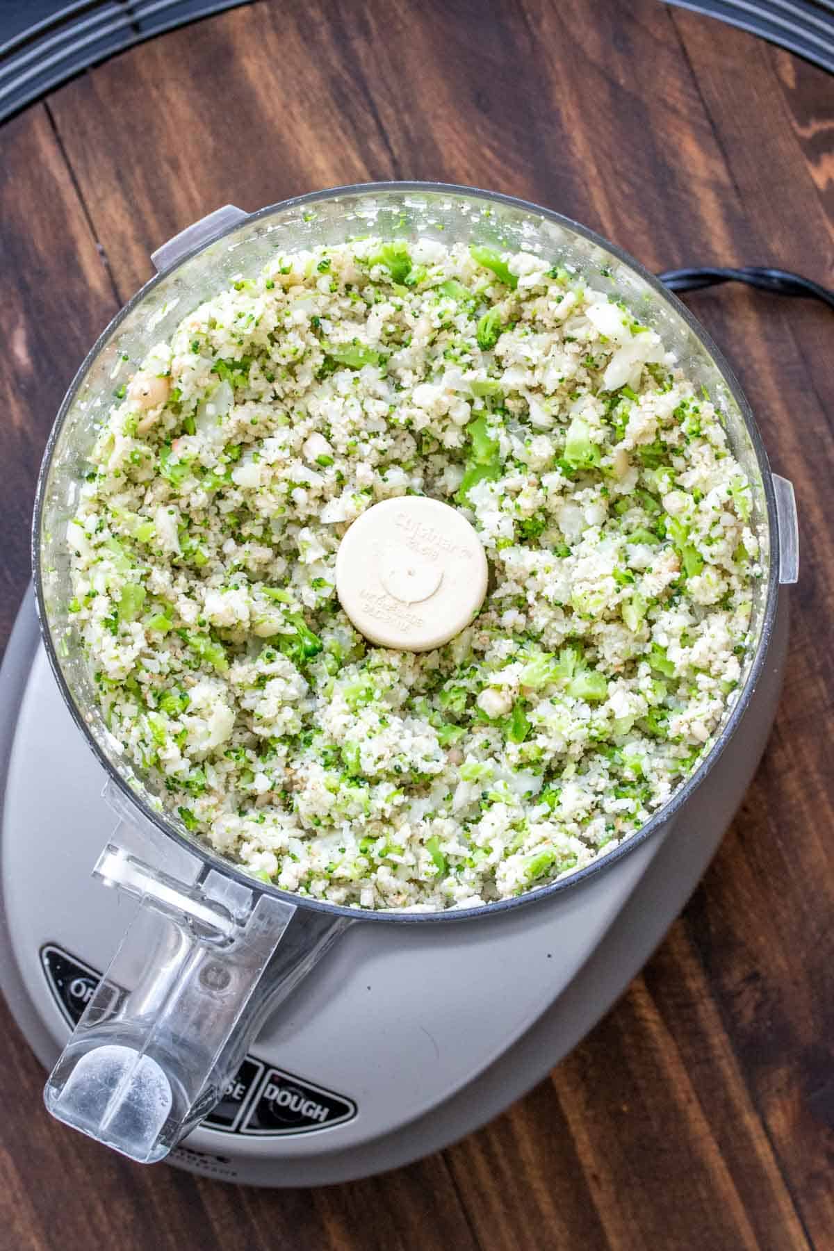 Food processor with broccoli cauliflower tot mixture.