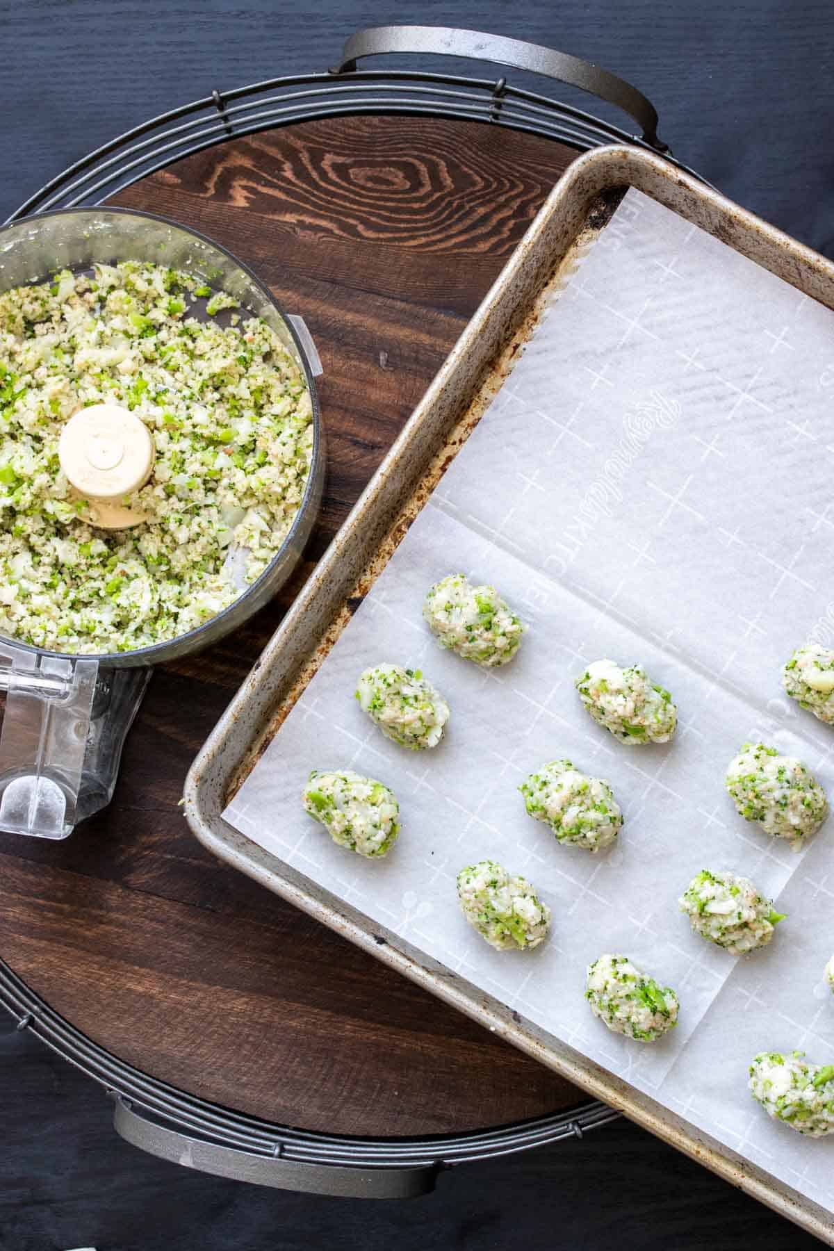 Broccoli cauliflower tot mixture being formed into tots on a cookie sheet