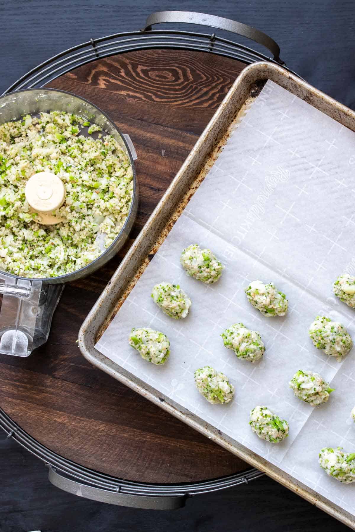 Broccoli cauliflower tot mixture being formed into tots on a cookie sheet.